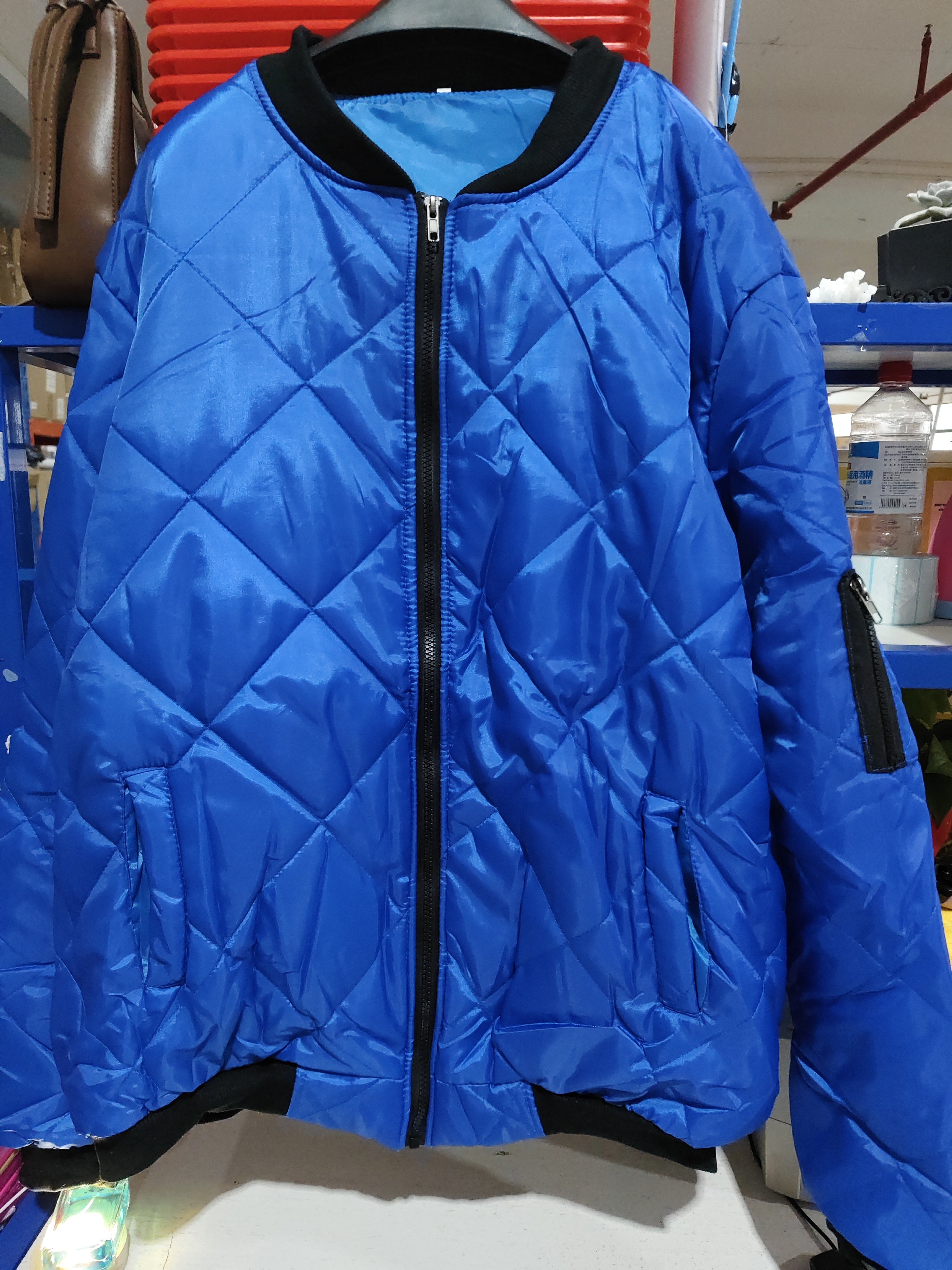 Solid color blue winter stand collar jacket for men, featuring a quilted design and zipper placket.